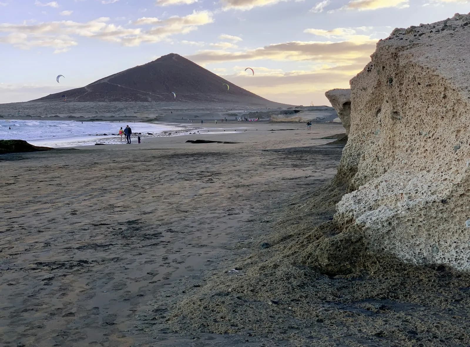 El Médano beach at sunset with the cone of Montaña Roja and kites over the sea