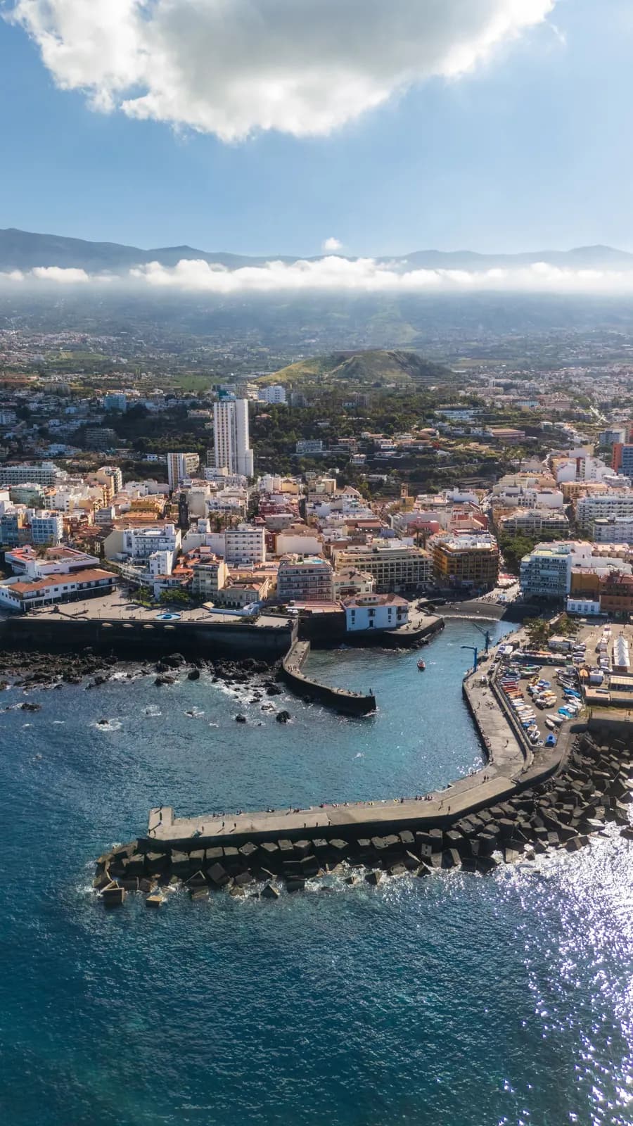 Aerial view of the fishing harbour in Puerto de la Cruz's old town, with its breakwater, moored boats and the Orotava Valley behind
